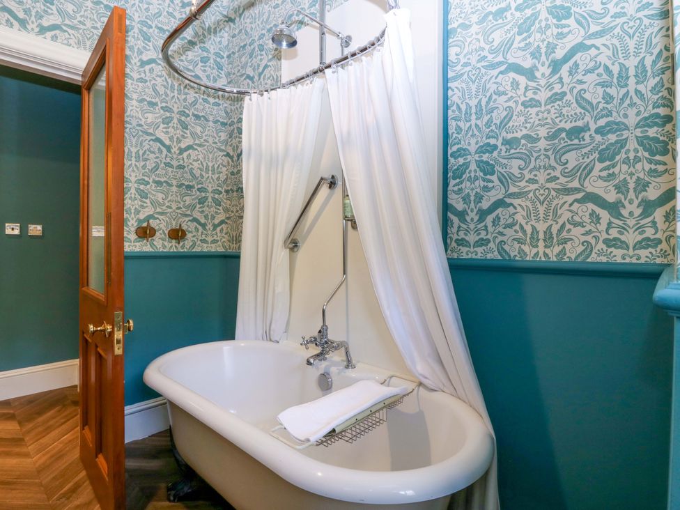 A bathroom with a bathtub and shower curtain at Braeriach - Mar Lodge Estate in Braemar