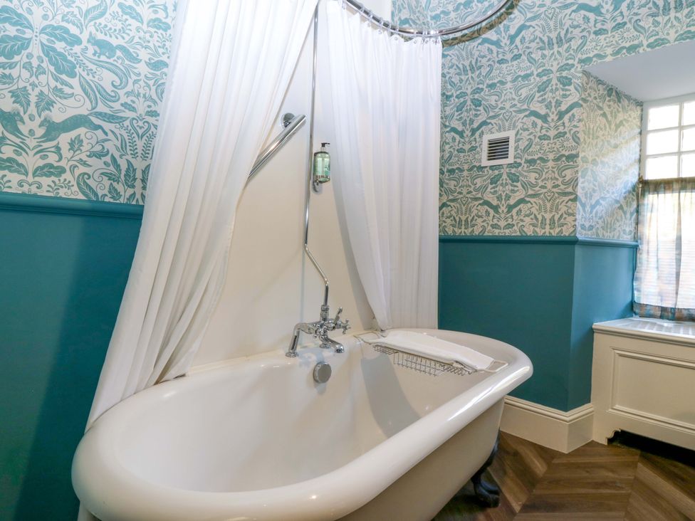 A bathroom with a bathtub and window at Braeriach - Mar Lodge Estate, Braemar