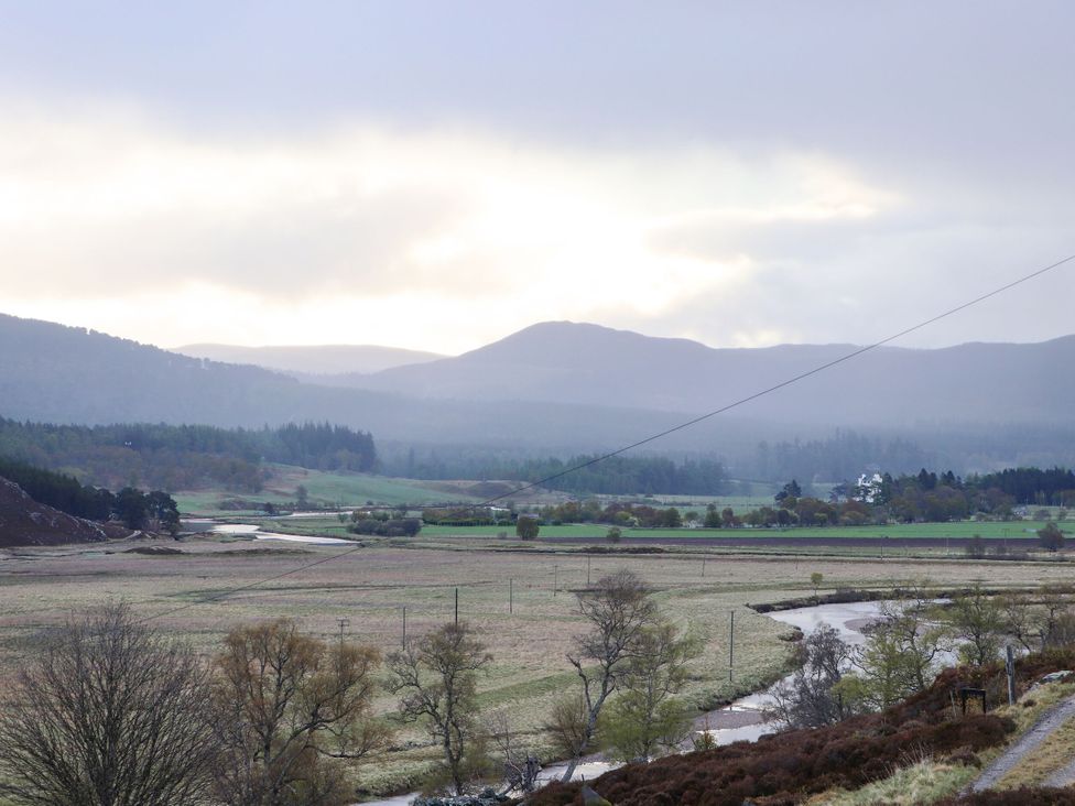 A landscape with mountains and a river at Bynack - Mar Lodge Estate in Braemar