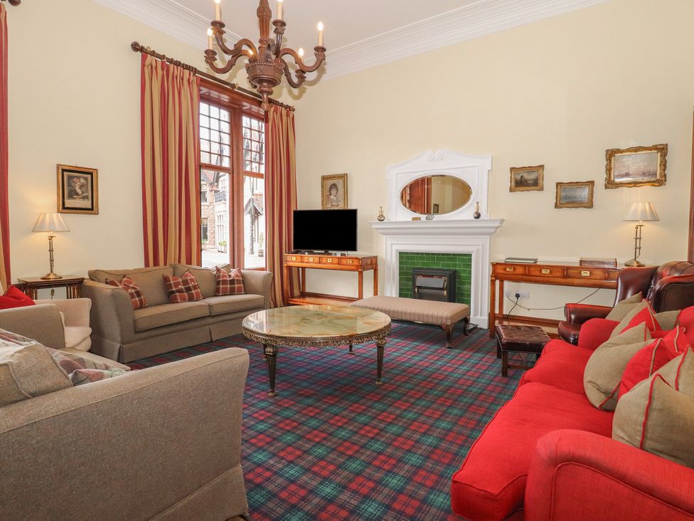 A living room with a television and a coffee table at Bynack - Mar Lodge Estate in Braemar