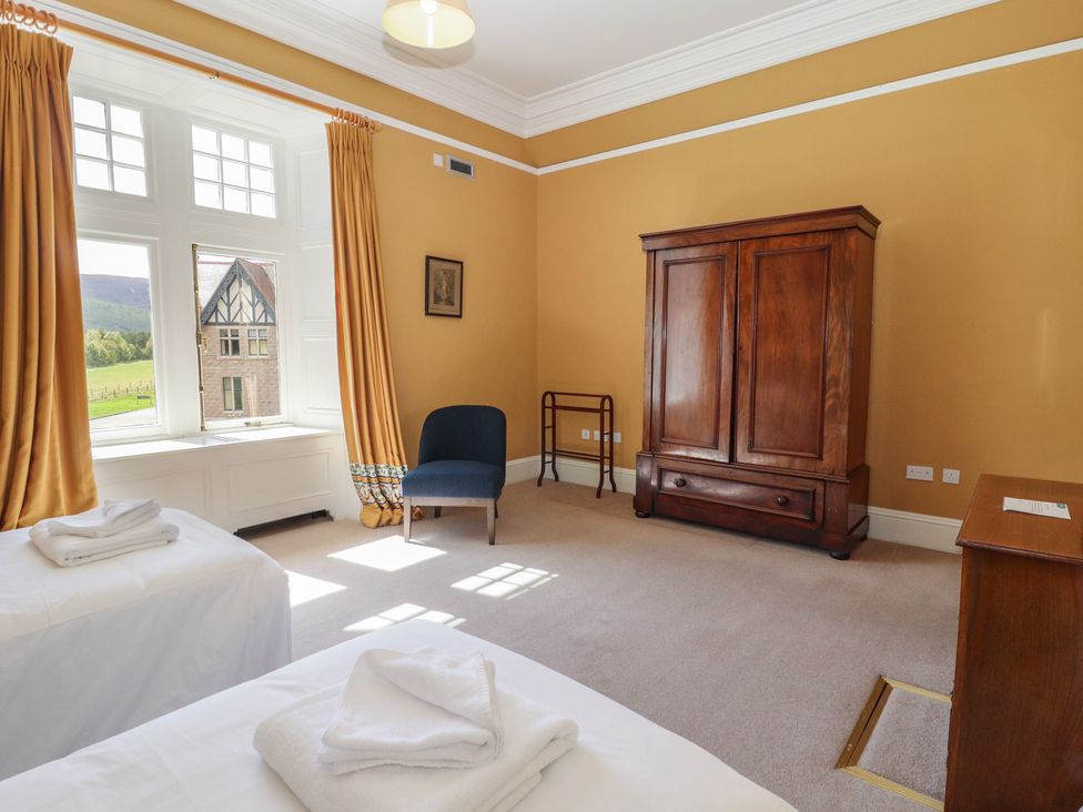 A bedroom with two beds and a wardrobe at Bynack - Mar Lodge Estate in Braemar