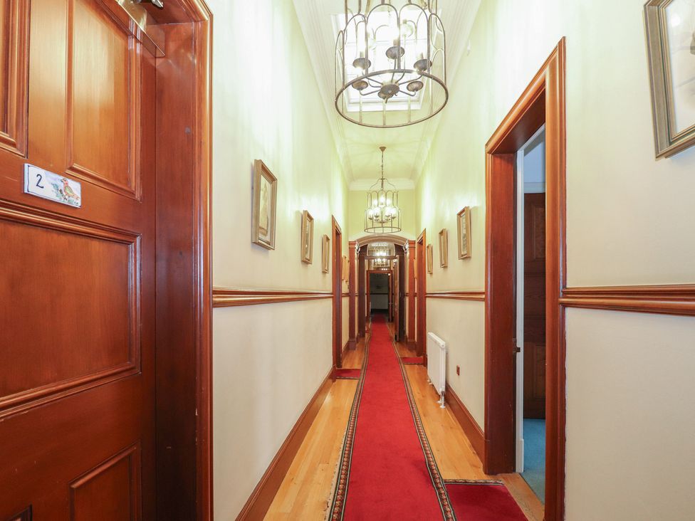 A hallway with doors and pictures at Bynack - Mar Lodge Estate in Braemar