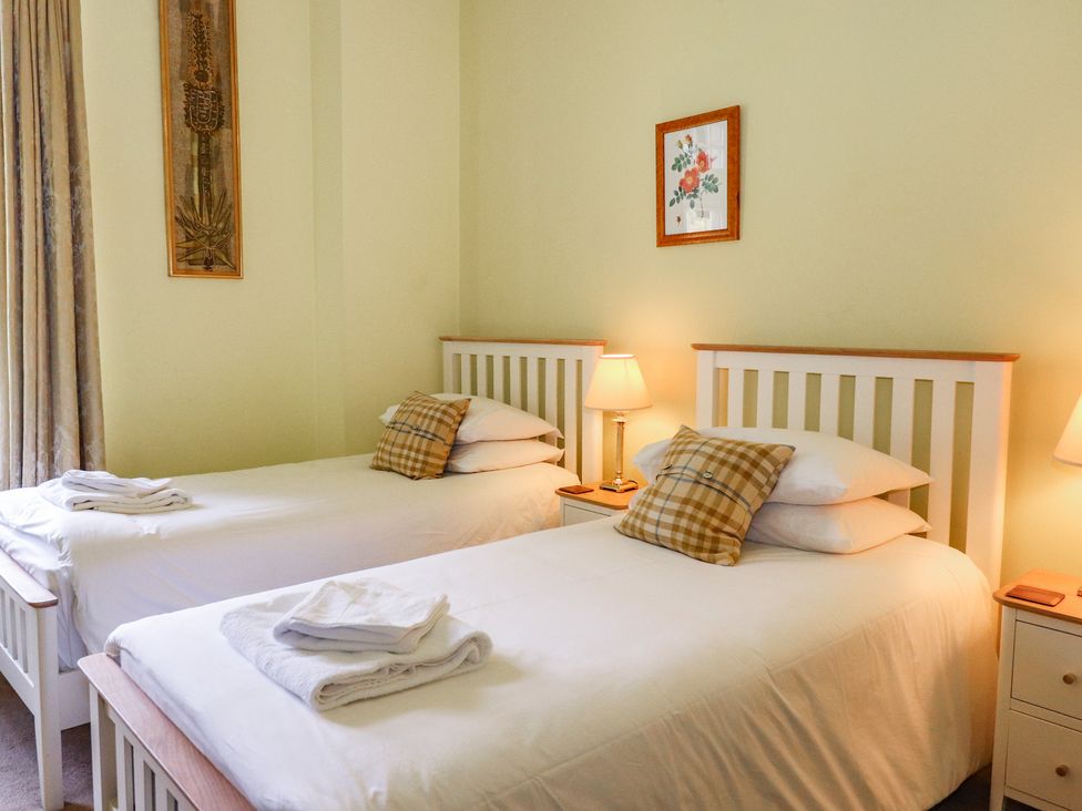 A bedroom with two beds and a lamp at Bynack - Mar Lodge Estate, Braemar
