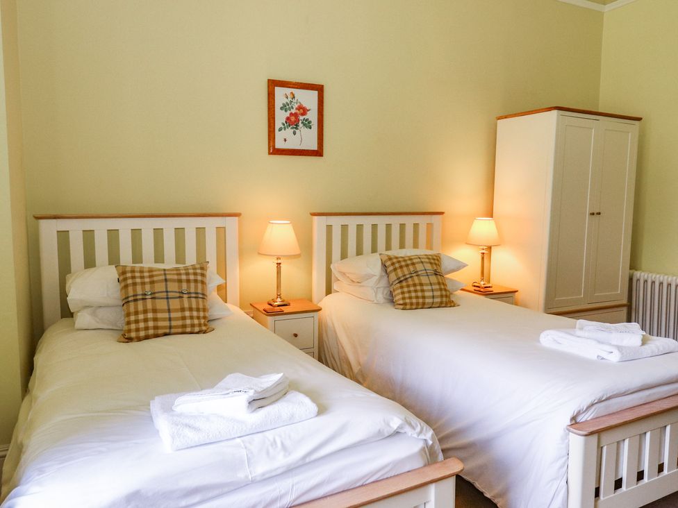 A bedroom with two beds and a wardrobe at Bynack - Mar Lodge Estate, Braemar
