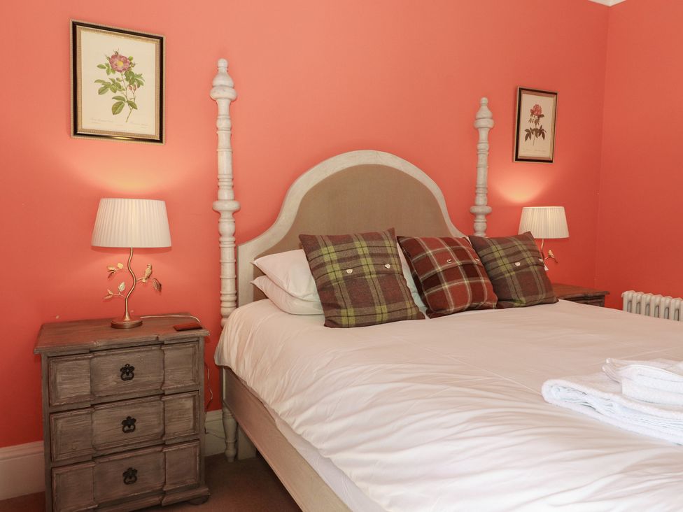 A bedroom with a bed and nightstand at Bynack - Mar Lodge Estate Braemar