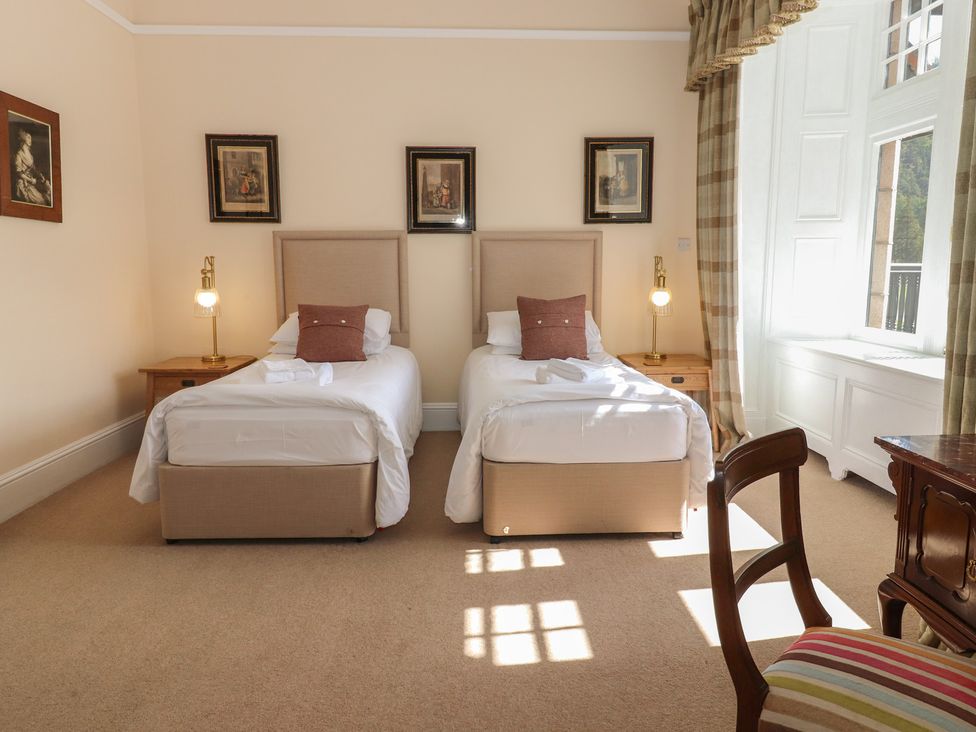 A bedroom with two single beds and a window at Bynack - Mar Lodge Estate in Braemar
