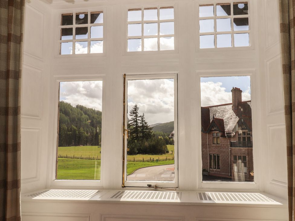 A view from a window showing landscape and a building at Bynack - Mar Lodge Estate in Braemar