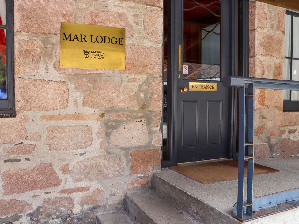 The entrance to Mar Lodge with a stone wall at Dalvorar - Mar Lodge Estate in Braemar