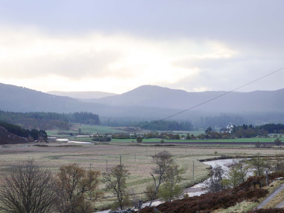 A landscape featuring mountains, fields, and a river at Dalvorar - Mar Lodge Estate, Braemar