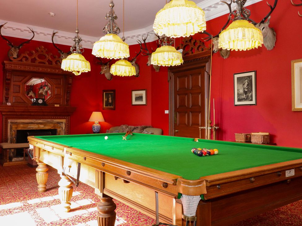 A game room with a snooker table and decorative mounted heads at Derry - Mar Lodge Estate in Braemar