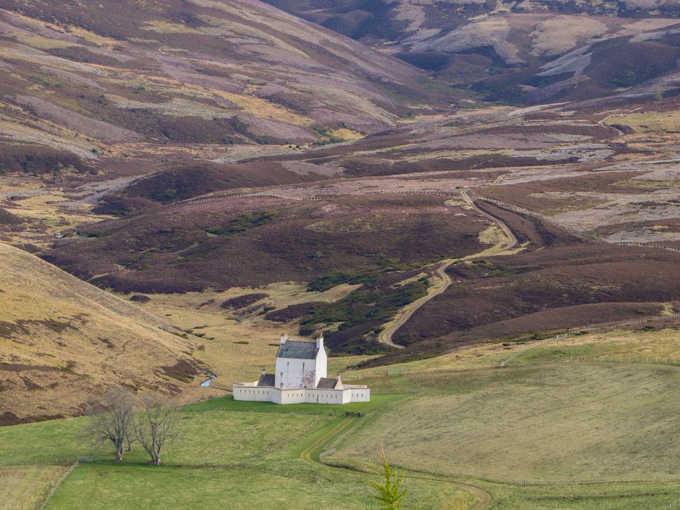 A building surrounded by hills and grass at Macdui - Mar Lodge Estate Braemar