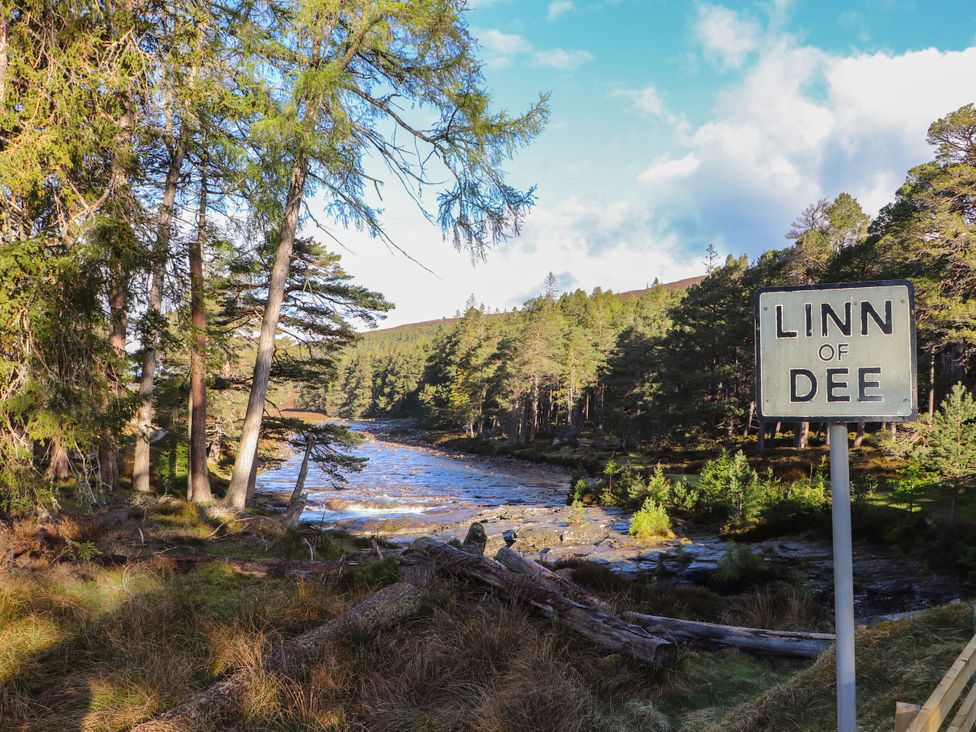 A natural landscape with a river and trees at Linn of Dee in Braemar