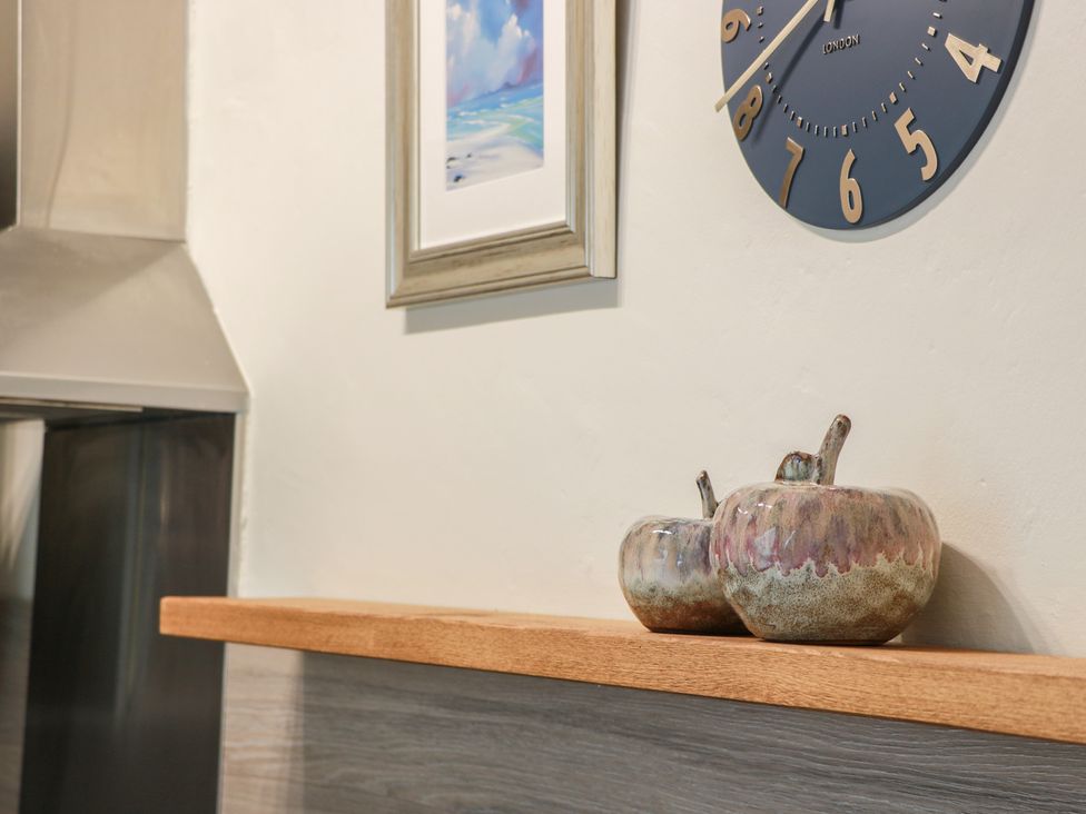A shelf with decorative items and a clock in the kitchen at North Segganwell - Culzean Castle Maybole