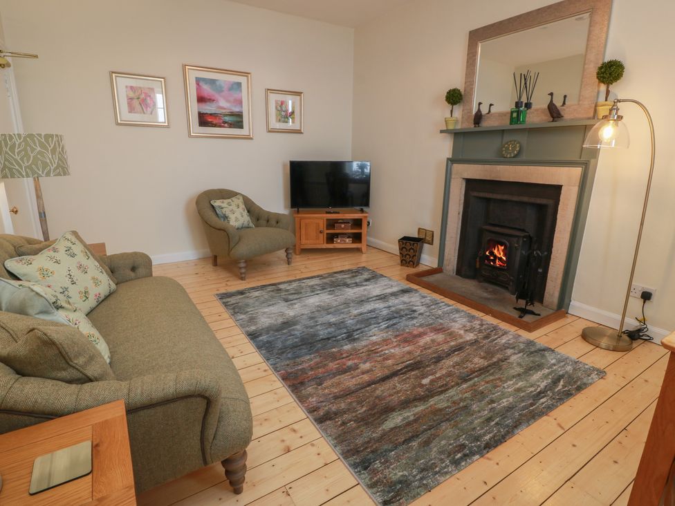 A living room with a sofa and fireplace at South Segganwell - Culzean Castle, Maybole
