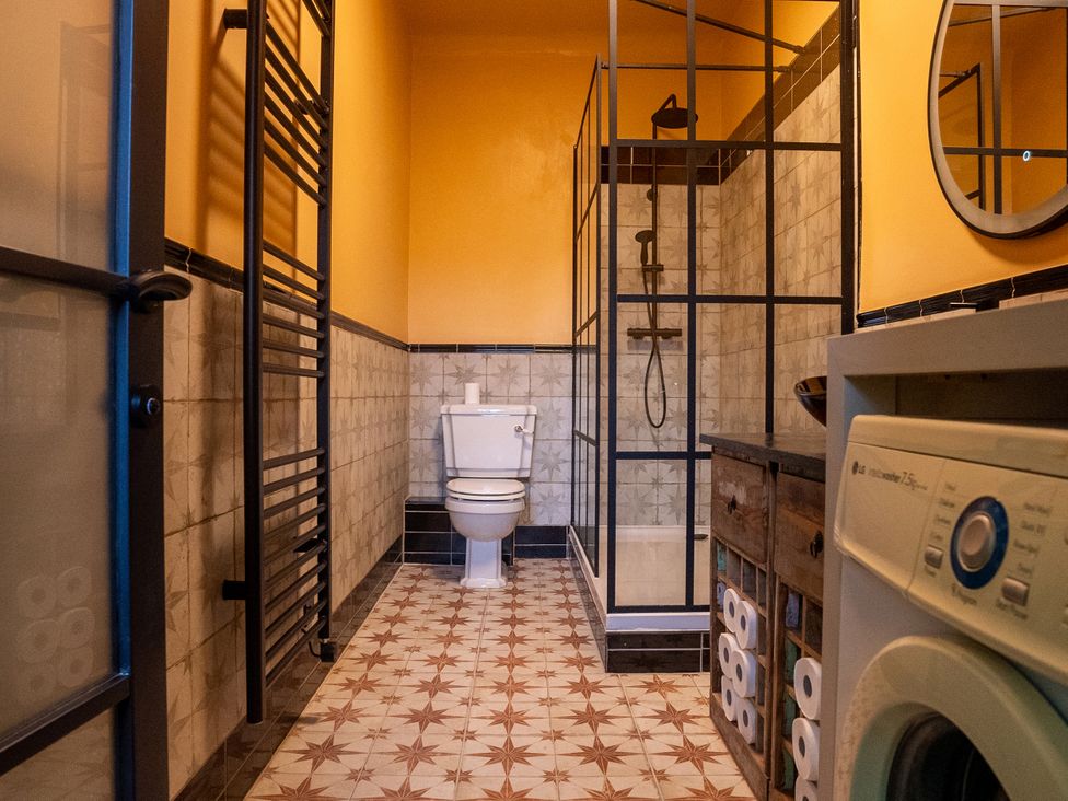 A bathroom with a shower, toilet, and washing machine at Royal Oak House in Motcombe