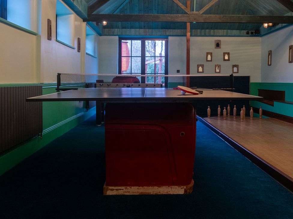 A ping pong table with a paddle and bowling pins at Royal Oak House in Motcombe