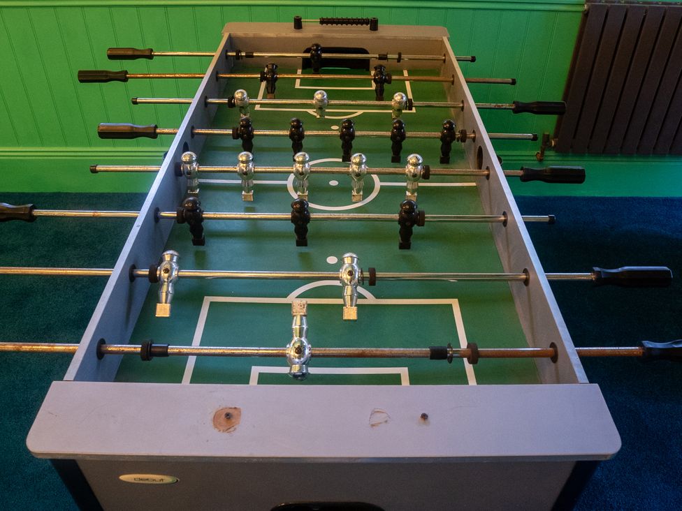 A foosball table with players and metal rods in a game room at Royal Oak House, Motcombe