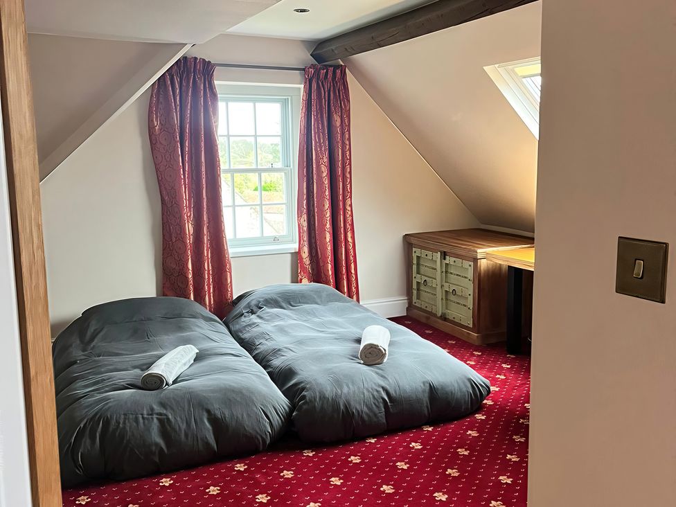 A bedroom with two beds and a desk at Royal Oak House in Motcombe