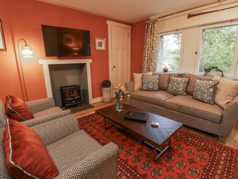 A living room with a sofa and armchair in The Coach House - Holmwood Glasgow