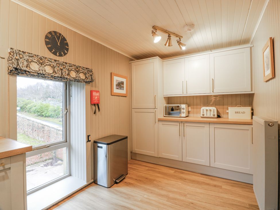 A kitchen with window and kitchen cabinets at The Coach House - Holmwood in Glasgow