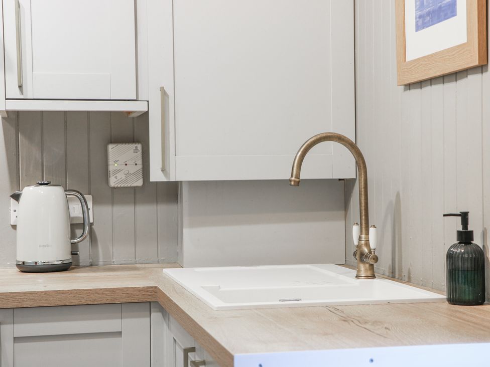 A kitchen with a kettle, sink and tap at The Coach House - Holmwood in Glasgow