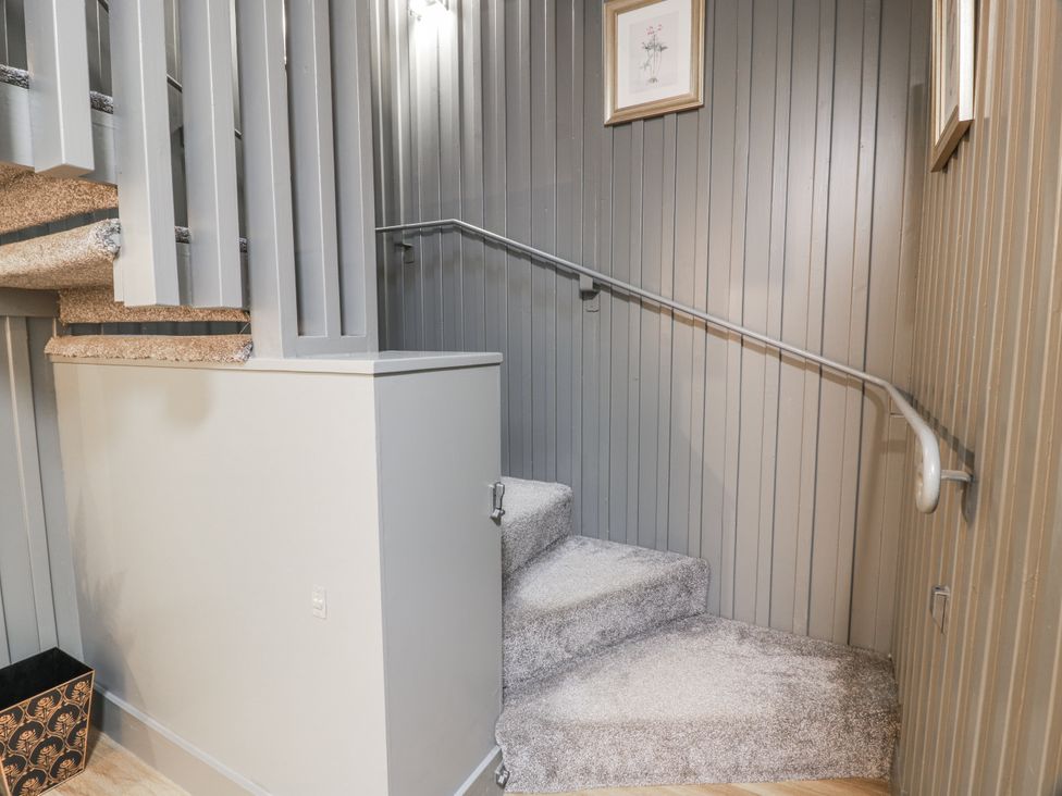 A staircase with a handrail in a hallway at The Coach House - Holmwood Glasgow