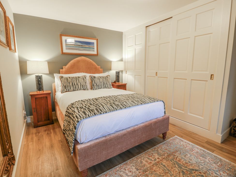 A bedroom with a bed and bedside tables at The Coach House - Holmwood, Glasgow