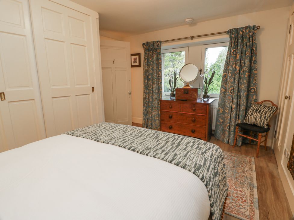 A bedroom with a bed and dresser at The Coach House - Holmwood in Glasgow