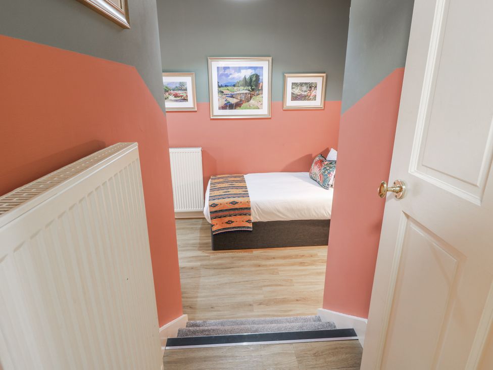 A bedroom with a bed and pictures on the wall at The Coach House - Holmwood, Glasgow
