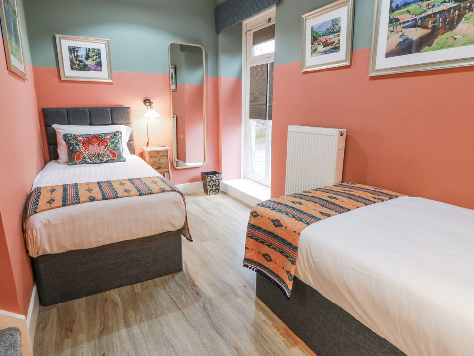 A bedroom with two beds, a mirror, and a nightstand at The Coach House - Holmwood in Glasgow