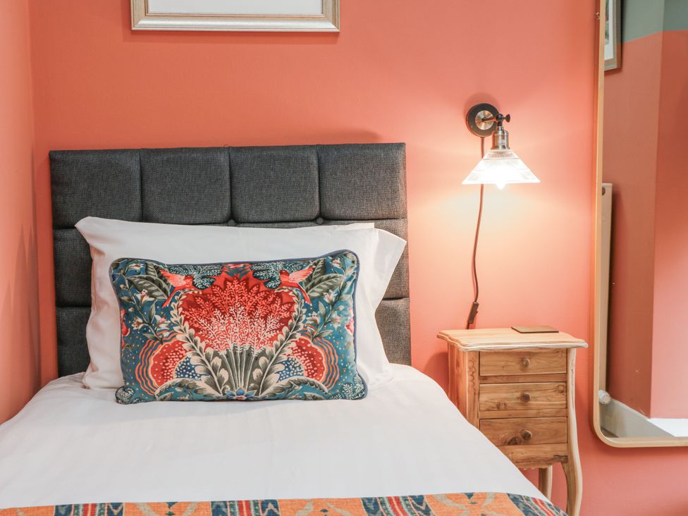 A bedroom with a bed and nightstand at The Coach House - Holmwood in Glasgow