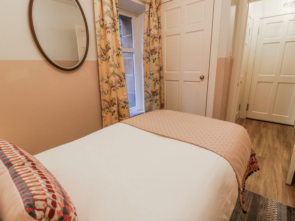 A bedroom with a bed and a mirror at The Coach House - Holmwood, Glasgow