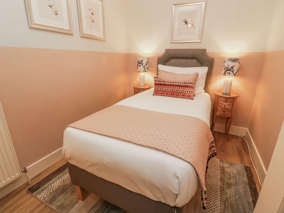 A bedroom with a single bed and bedside tables at The Coach House - Holmwood in Glasgow