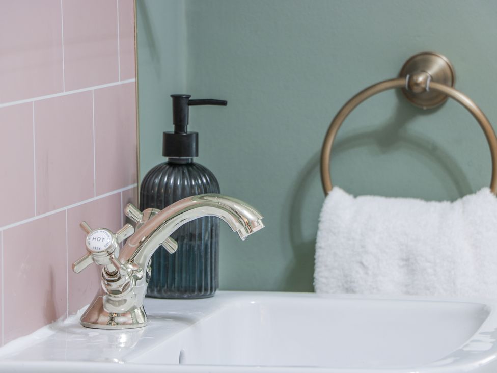A sink with a faucet and a towel in a bathroom at The Coach House - Holmwood Glasgow