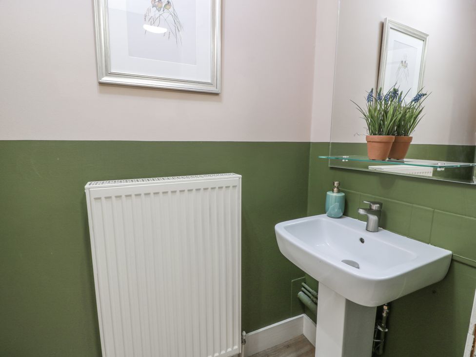 A bathroom with a sink and a radiator at The Coach House - Holmwood Glasgow
