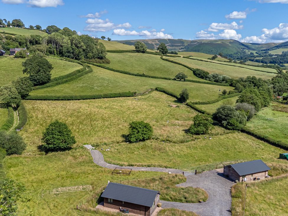 A view of fields and trees at Birch Banc Retreats - Bedw Llanidloes
