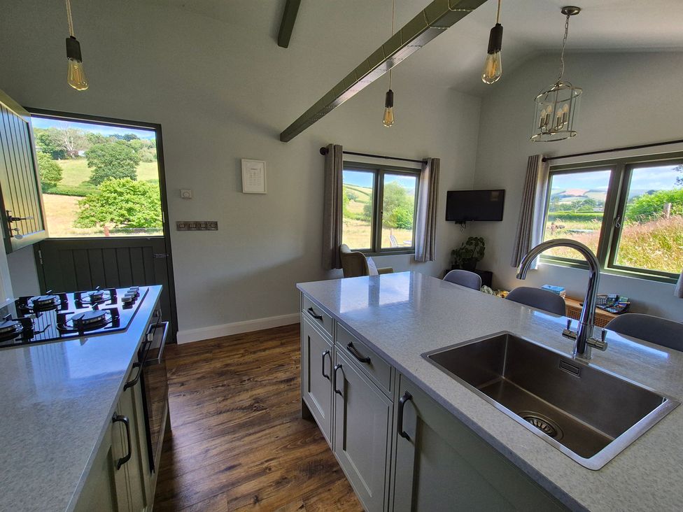 A kitchen with a gas stove and sink at Birch Banc Retreats - Bedw Llanidloes