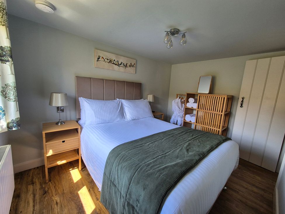 A bedroom with a bed and shelves at Birch Banc Retreats - Bedw Llanidloes