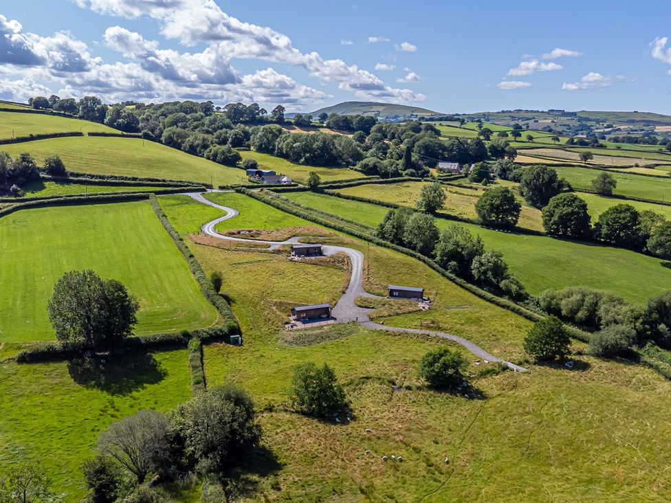 An aerial view of fields and cabins at Birch Banc Retreats - Bedw in Llanidloes