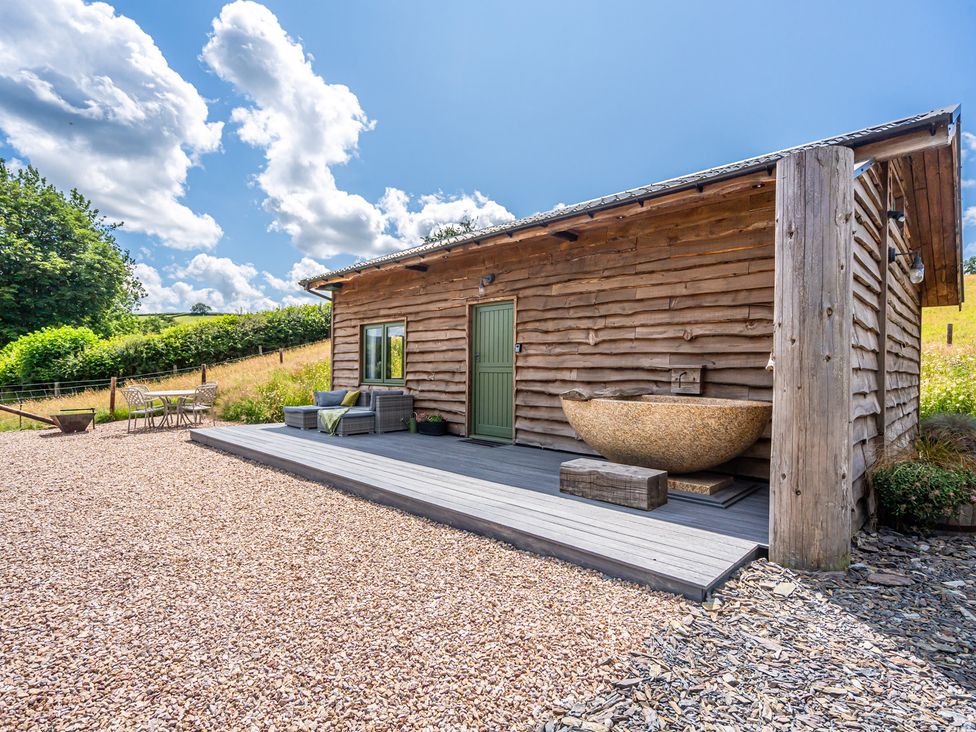 An outdoor view of a wooden building with a deck at Birch Banc Retreats - Bedw Llanidloes
