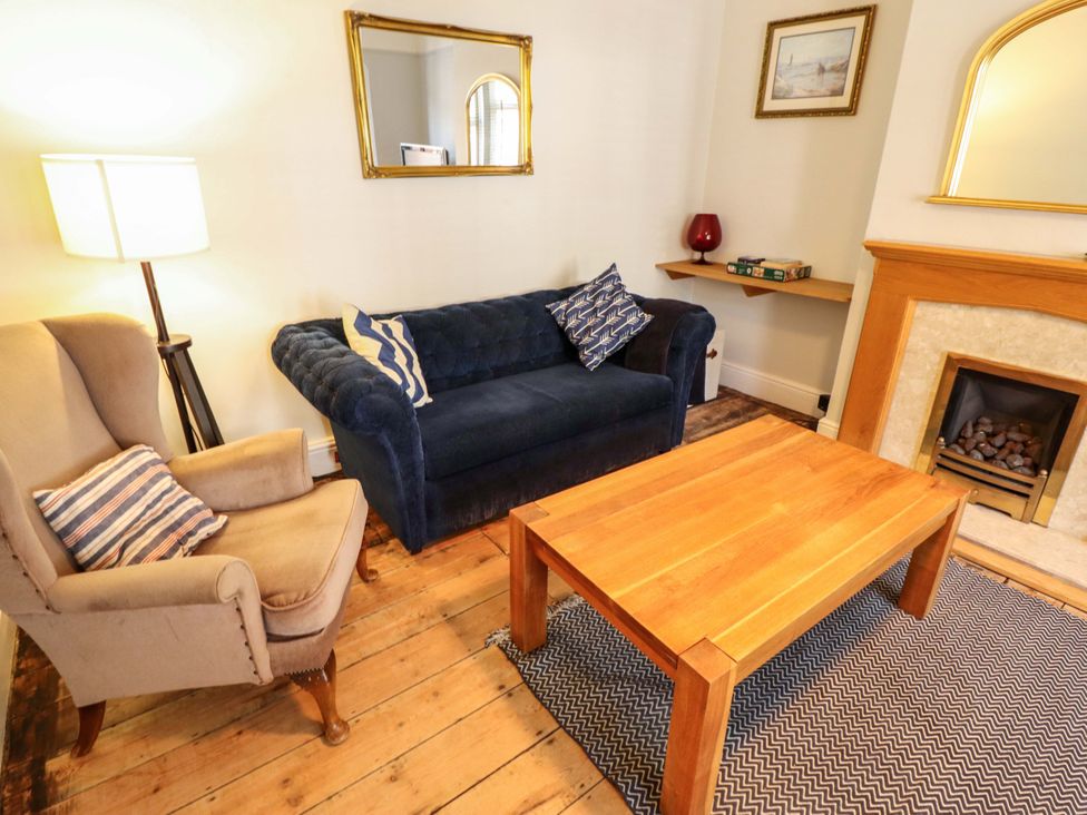 A living room with a blue sofa and wooden coffee table at Maples in Hunstanton