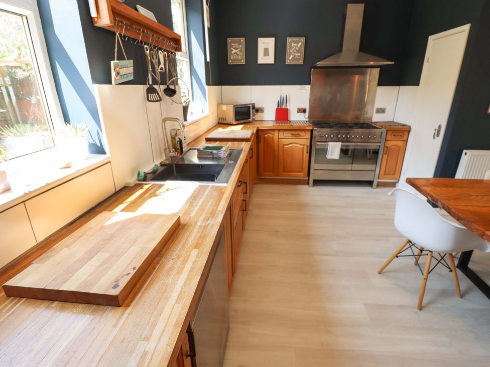A kitchen with wooden cabinets and appliances at Maples in Hunstanton