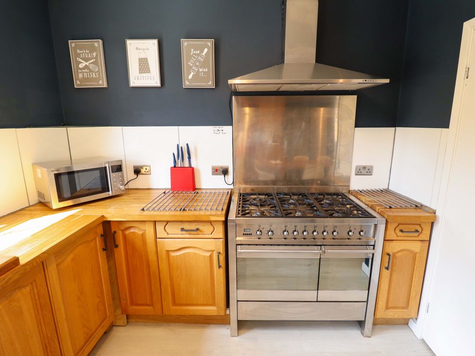 A kitchen with an oven and microwave at Maples in Hunstanton