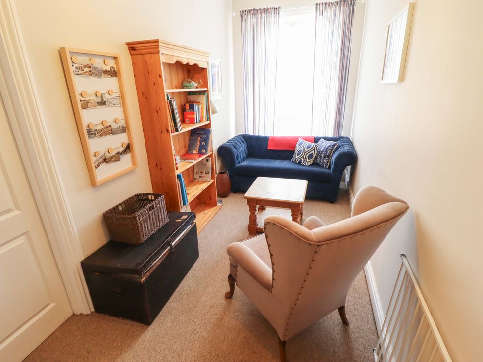 A snug with a sofa and bookshelf at Maples in Hunstanton