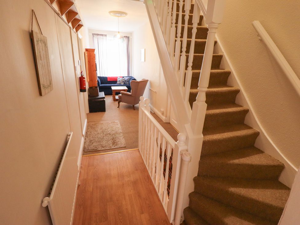 A hallway with a staircase and seating area at Maples in Hunstanton
