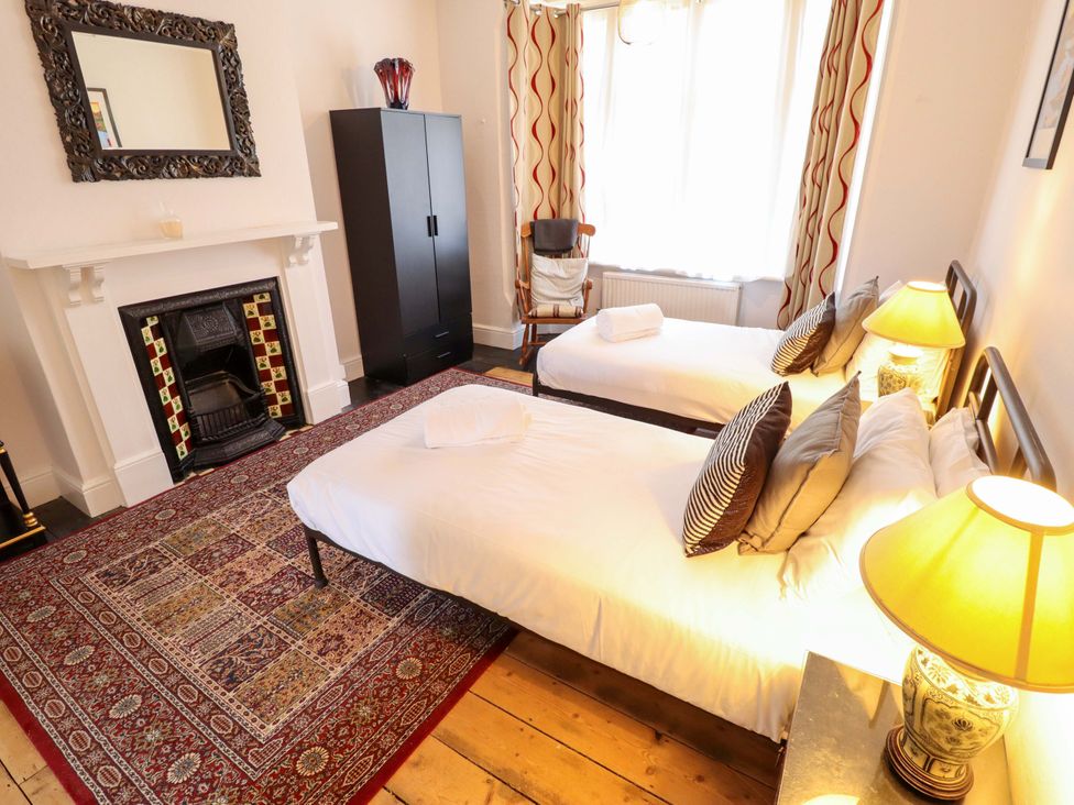 A bedroom with two beds and a fireplace at Maples in Hunstanton