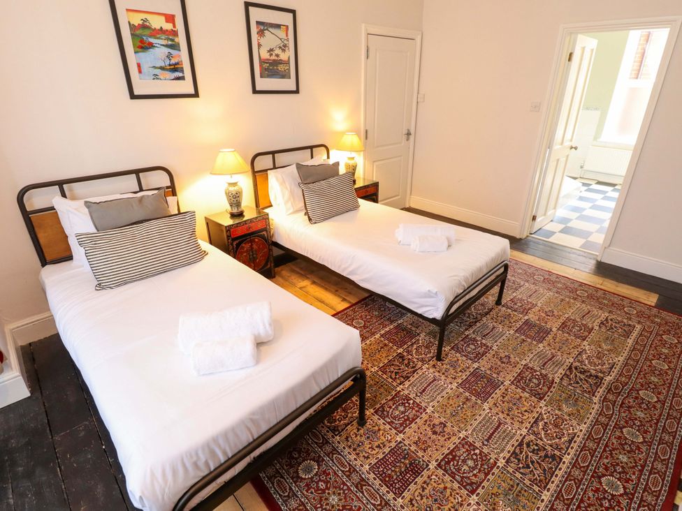 A bedroom with two single beds and lamps at Maples in Hunstanton