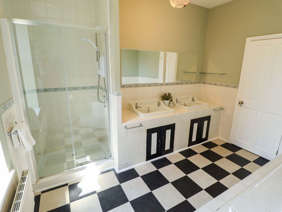 A bathroom with sinks and a shower at Maples in Hunstanton