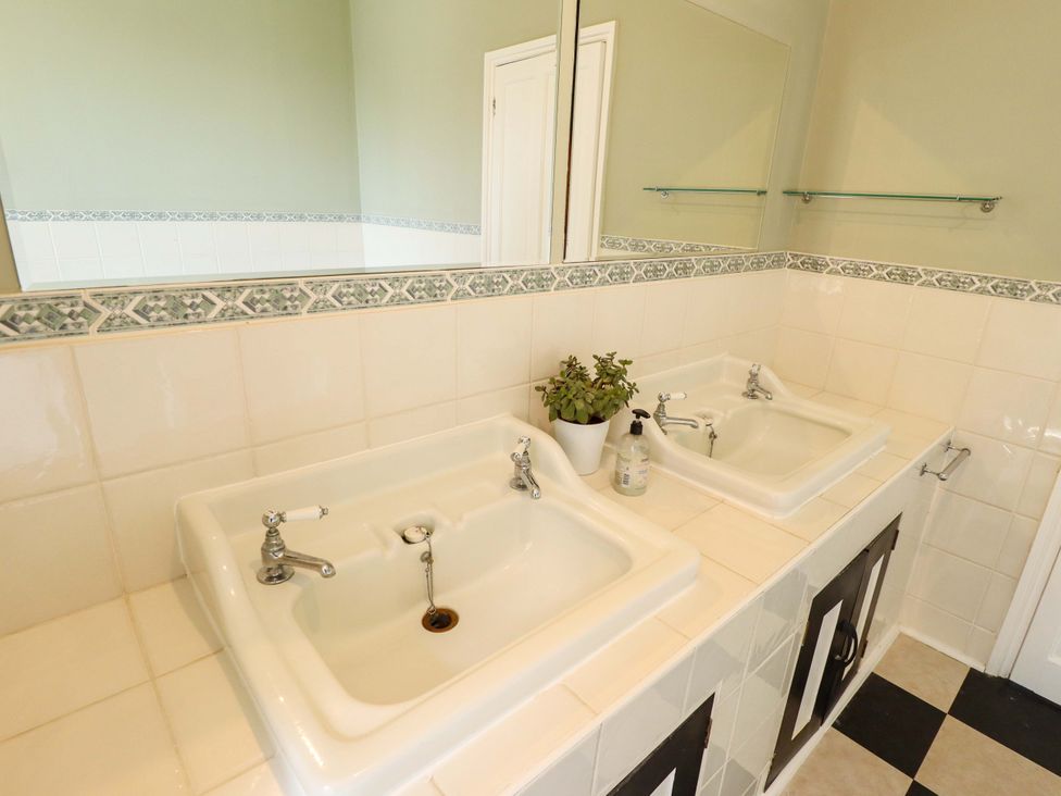 A bathroom with two sinks and a mirror at Maples in Hunstanton