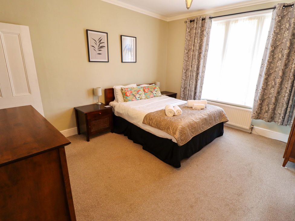 A bedroom with a bed and bedside table at Maples in Hunstanton